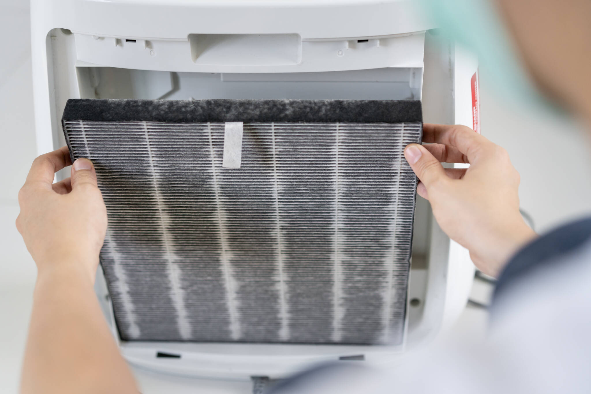 Asian Woman Changing The Dirty Air Purifier Filter After Using For A Long Time In The Dirty Air Environment. Using Air Purifier Clean The Air For Better Atmosphere In A House. Asian Woman Changing The Dirty Air Purifier Filter After Using For A Long Time In The Dirty Air Environment. Using Air Purifier Clean The Air For Better Atmosphere In A House.